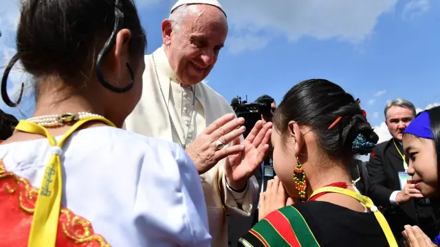 El Papa saludando a niños a su llegada a Birmania.