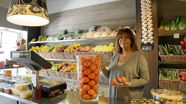 Ana Cameo muestra unas mandarinas en su tienda, en la calle Embarcadero, 26, en el barrio zaragozano de Casablanca.