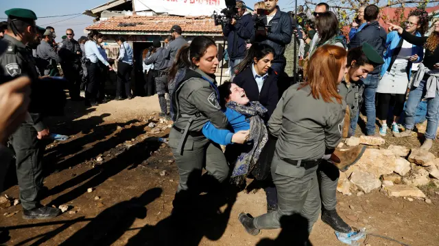 La policía israelí desaloja a una mujer de una de las estructuras de Netiv Haavot, la cual debe ser demolida antes de marzo de 2018