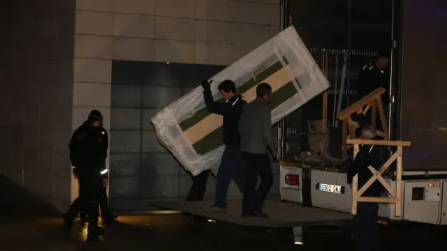 Los operarios descargan de los camiones los embalajes en los que retornarán las piezas a Sijena