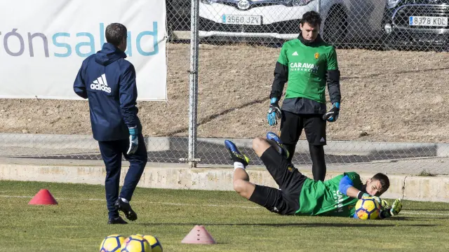 Ratón atrapa un balón en un ejercicio en la Ciudad Deportiva ante la mirada de Cristian Álvarez.