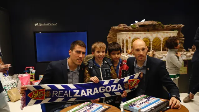 Dos niños se fotografían con Zapater y Toquero sosteniendo una bufanda del Real Zaragoza