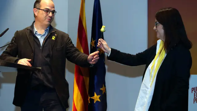 El exconsejero Jordi Turull le entrega una rosa amarilla a la esposa de Jordi Sánchez durante un mitin.