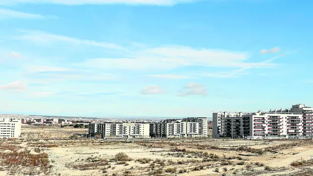 Vista de Arcosur desde el Cuarto Cinturón, con el bloque más compacto de viviendas y varias parcelas que esperan la llegada de las obras.