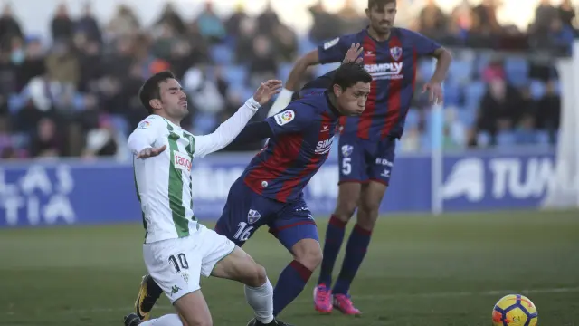 Chimy Ávila, que la pasada jornada estrenó su cuenta anotadora  pelea por la pelota durante el Huesca-Córdoba (3-1).