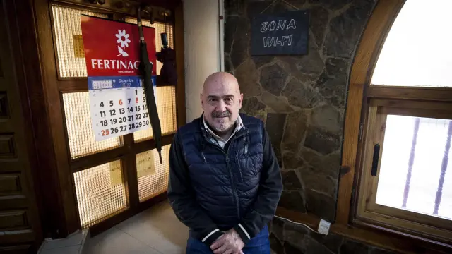 Alberto Báguena, fundador del bar El Arco, junto con el cartel de wifi.
