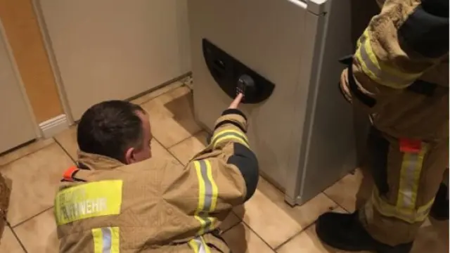 Un bombero libera a un menor atrapado en una caja fuerte.