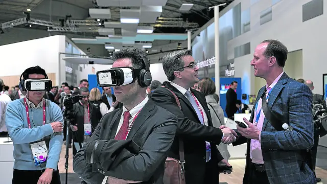 Asistentes al pasado congreso mundial de telefonía prueban unas gafas de realidad virtual.