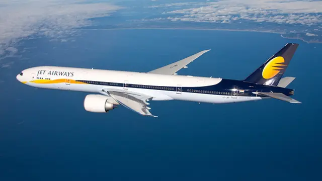 Avión de Jet Airways, blanco con detalles azules y amarillos.