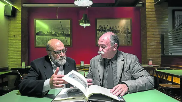 Eduardo Bayón y Francisco Núñez ojean un libro de la historia de los Hércules.
