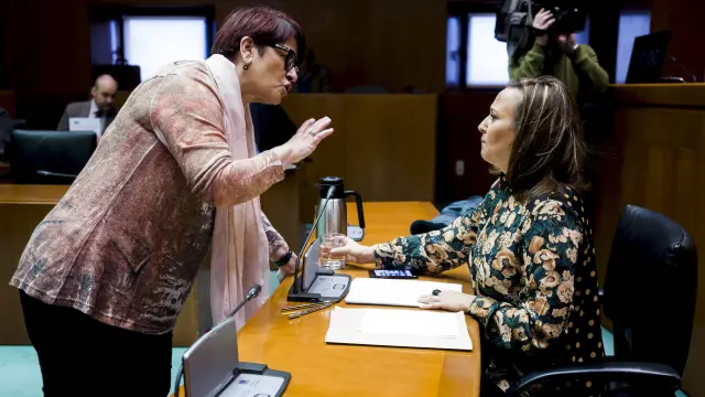 Margarita Périz, del PSOE, habla con la consejera de Educación, Mayte Pérez, antes de dar comienzo la comparecencia