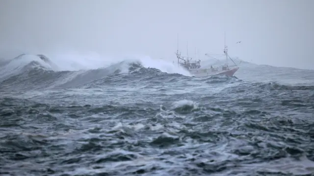 Un barco arriba al puerto de Burela, en Lugo, en medio del fuerte temporal.