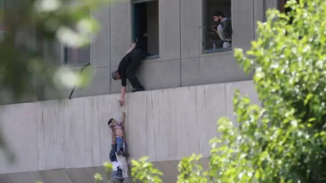 Un joven es evacuado durante el ataque al parlamento iraní en junio de 2017