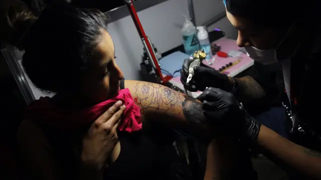 Una mujer se reliza un tatuaje