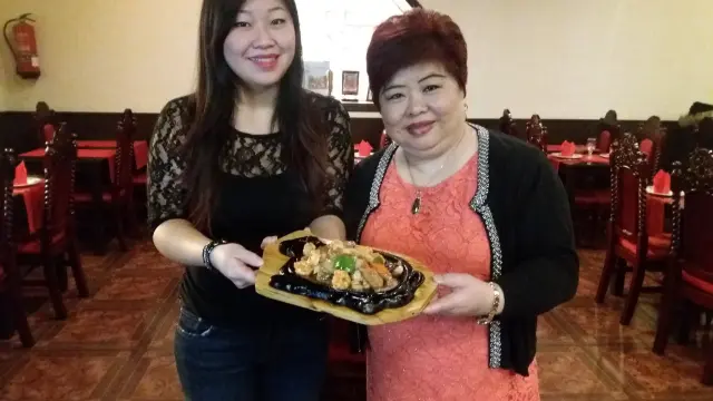 Isa y su madre, Shuhong, con un plato de Familia Feliz, típico de esta celebración.
