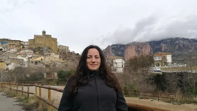 La alcaldesa de Murillo de Gállego posa ante el pueblo y los Mallos de Riglos.
