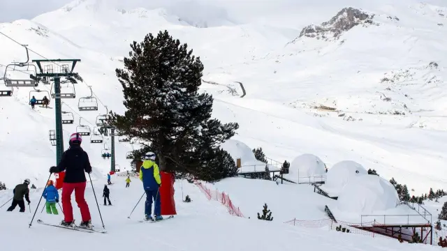 Unos esquiadores, junto a los 'iglús' para pernoctar junto al ibón de Culivillas, montados en otoño.