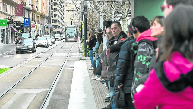 Varios usuarios esperan un tranvía en Gran Vía durante el horario de paros matinales del martes.