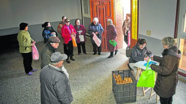 Charo Tirado hace el reparto de pan a los vecinos de Alarba en los bajos del Ayuntamiento.