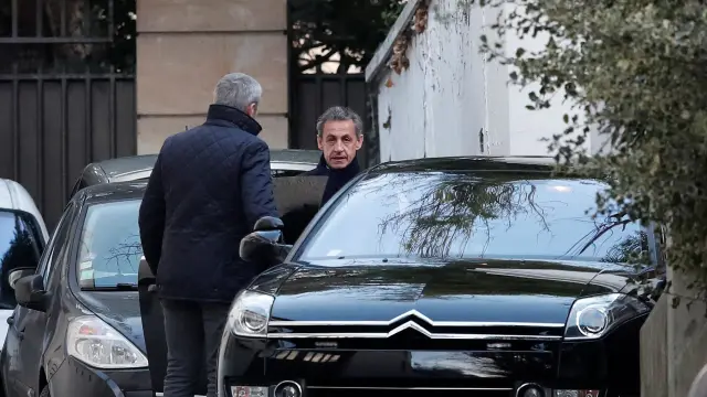 Sarkozy  saliendo de su domicilio en París acompañado por su abogado para dirigirse al interrogatorio
