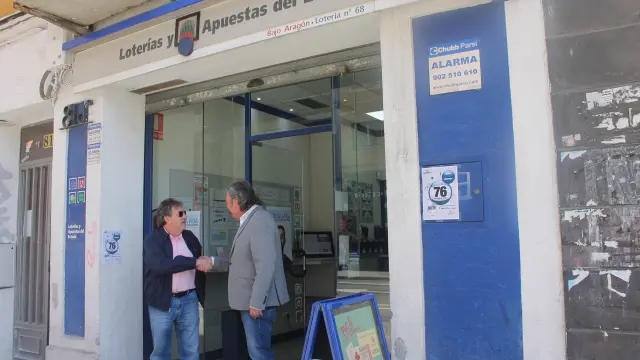 Pedro Catalán, representante en Aragón de la Agrupación Nacional de Asociaciones Provinciales de Administradores de Loterías, saluda a un cliente ya jubilado en su administración de la calle Miguel Servet.