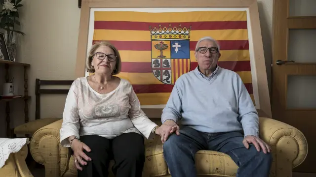 Miguel Dalmau y Herminia Blanco con la bandera que confeccionó ella hace cuatro décadas.