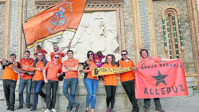 Representantes de las peñas naranjas posan en La Escalinata ilusionados con ganar el triplete en la cancha del eterno rival, el Unicaja.