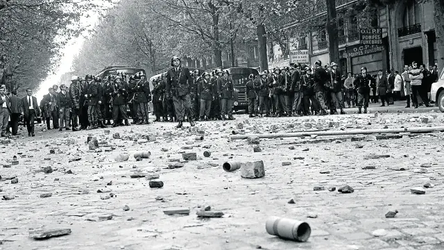 Policías frente a un escenario de violencia, con adoquines levantados, el 6 de mayo del 68 en París.