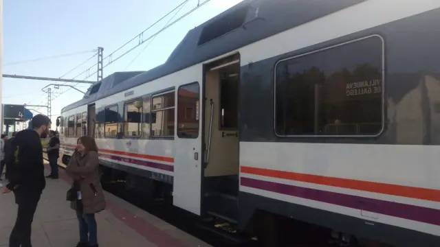 Viajeros esperando que les recoja un nuevo tren junto al convoy averiado en la estación de Villanueva, este sábado 5 de mayo.