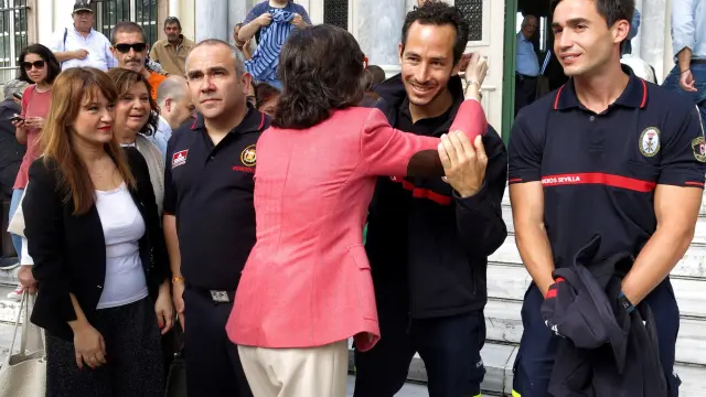 La consejera de Justicia de la Junta de Andalucía, Rosa Aguilar abraza a uno de los bomberos.