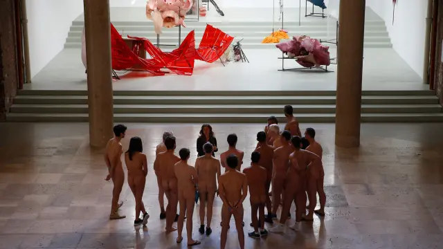 Un grupo de visitantes nudistas contemplando la muestra 'Discordia, hija de la noche'.