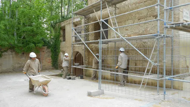 Varios integrantes del taller de empleo trabajando en una de las fachadas.