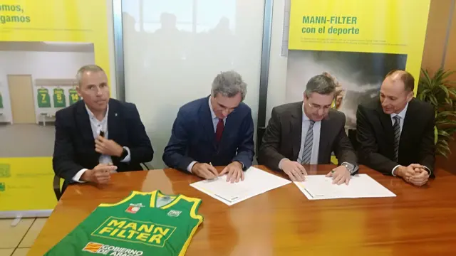 Javier Sierra, presidente del Stadium Casablanca (i), y Javier Sanz, director general de Mann+Hummel Ibérica (d), firman el acuerdo. A su lado, representantes de ambas entidades