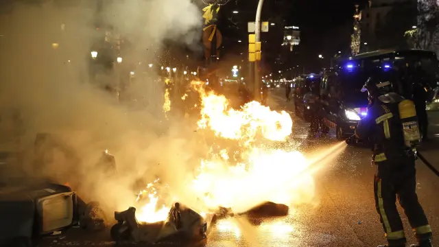 Contenedores de basura incendiados en el Paseo de Gracia de Barcelona en protesta por la detención de Carles Puigdemont.