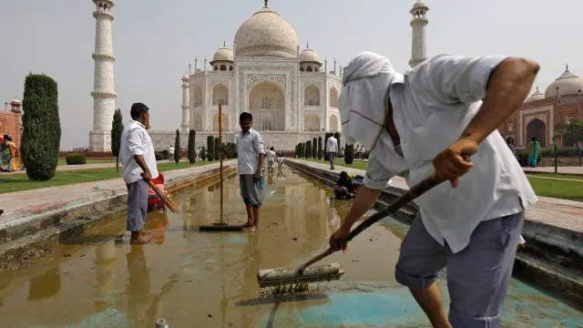 Trabajadores limpian la fuente del Taj Mahal