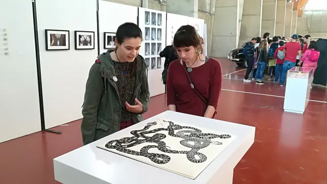 Dos jóvenes observan una de las obras de 'Festival Garbo', en el marco de la Feria Juventud Activa