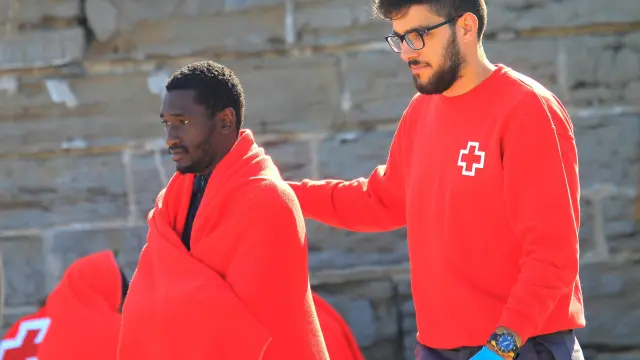 Un voluntario de la Cruz Roja acompaña a un inmigrante en el Estrecho de Gibraltar