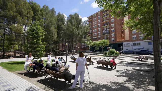 Usuarios del Aula de Demencias descansan tras un paseo por el parque de los Fueros.