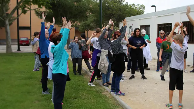 El grupo de paseos saludables y los alumnos del IES El Picarral, frente a la casa del barrio de Parque Goya