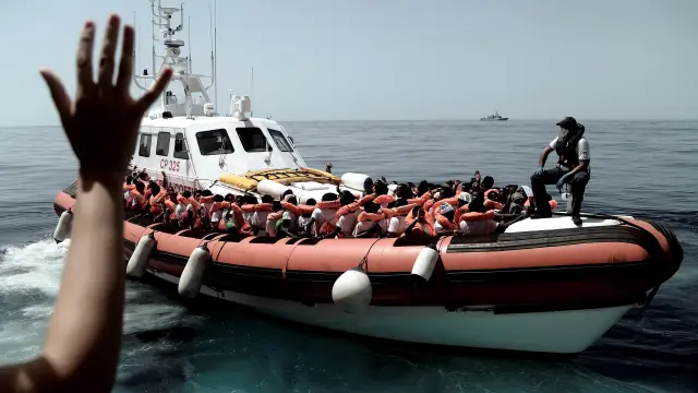 Inmigrantes transferidos a una patrullera de la Guardia Costera italiana.