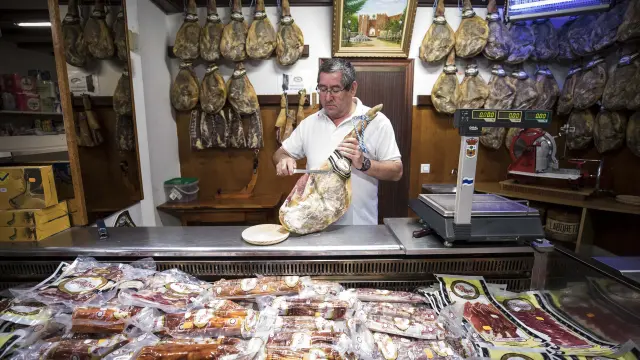 Luis Antonio Roqueta, de Casa Roqueta, corta jamón en el establecimiento