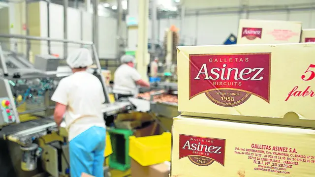 Dos trabajadoras envasan galletas en las nuevas instalaciones de Asinez en el polígono Empresarium de Zaragoza.