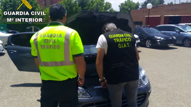 Dos guardias civiles inspeccionan uno de los vehículos manipulados por el sospechoso.