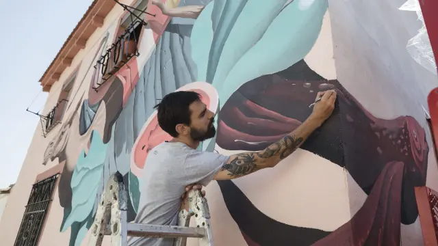 Denis Galocha, del equipo Twee Muizen, repasa un detalle de su mural, una suerte de "bodegón con animales".