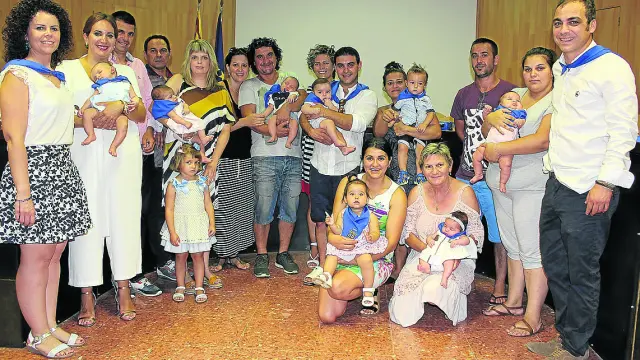 Fotografía de grupo de los niños recién nacidos con sus padres y autoridades.