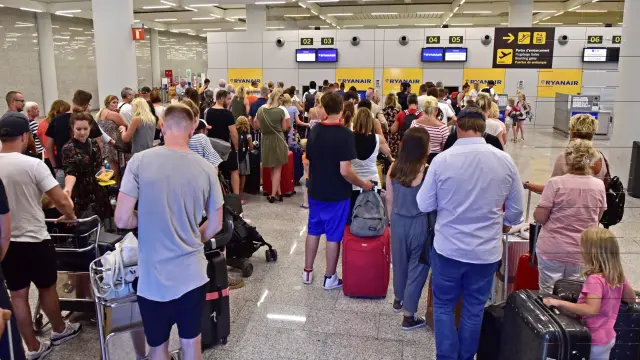 Pasajeros afectados por la huelga de Ryanair esperan en el aeropuerto de Palma de Mallorca.