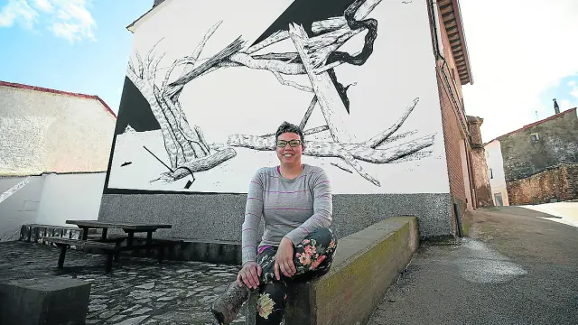La alcaldesa de Aladrén, Marta Blanco, ante uno de los murales del municipio.