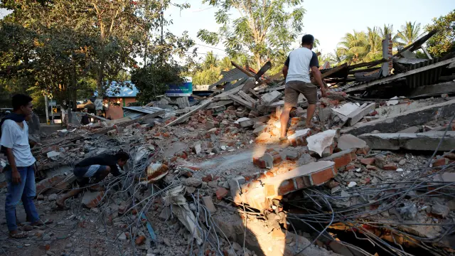 Vecinos de Lombok buscan supervivientes bajo los escombros.