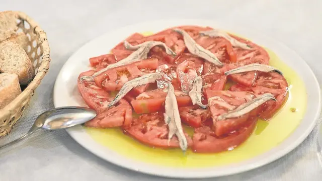 Una apetitosa ensalada de tomate con boquerones de Los Cartujos, uno de los restaurantes de referencia de Manuel Teruel.