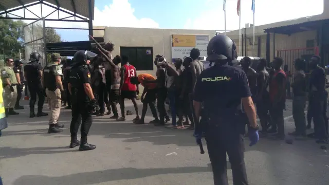 Varios inmigrantes custodiados por efectivos de la Policía Nacional.